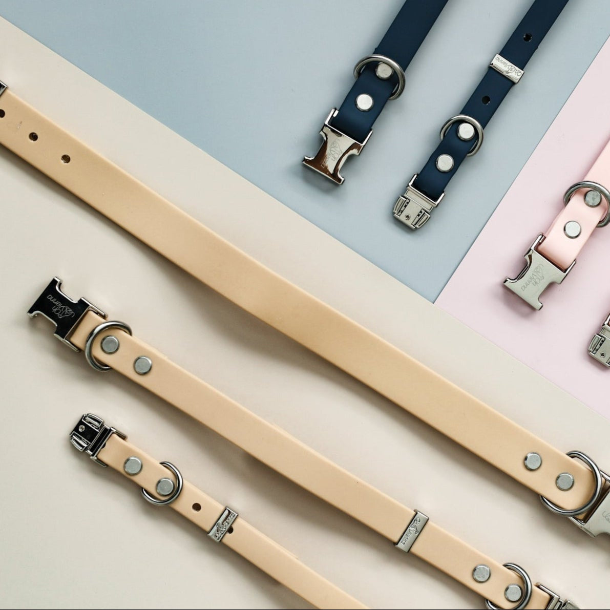 Tan, blue, and pink Oh Vienna dog collars flatlayed on a neutral background.